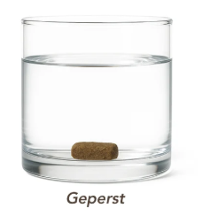 Geperste hondenbrok: de brok zakt naar de bodem van een glas water